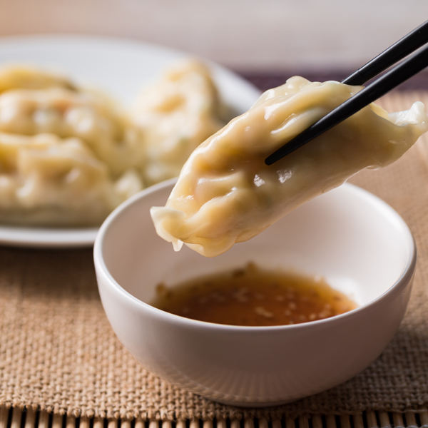 Gyoza being dipped in sauce