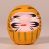 Mini traditional Japanese Daruma doll in yellow