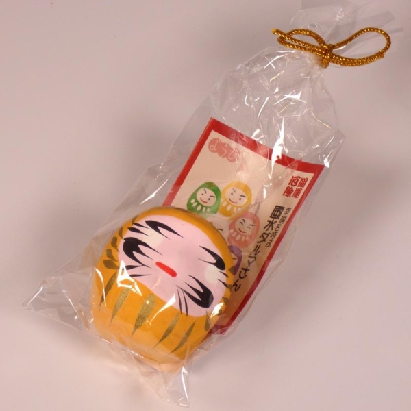 Mini traditional Japanese Daruma doll in yellow