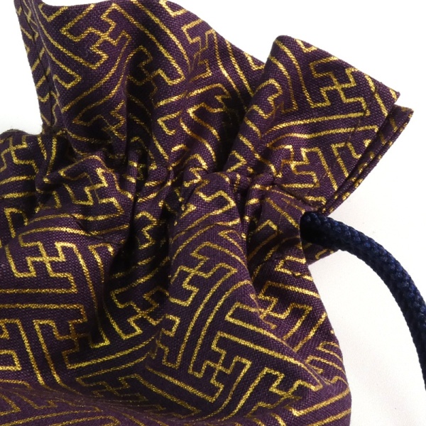Close up of drawstring top of dark purple geometric key pattern fabric bag