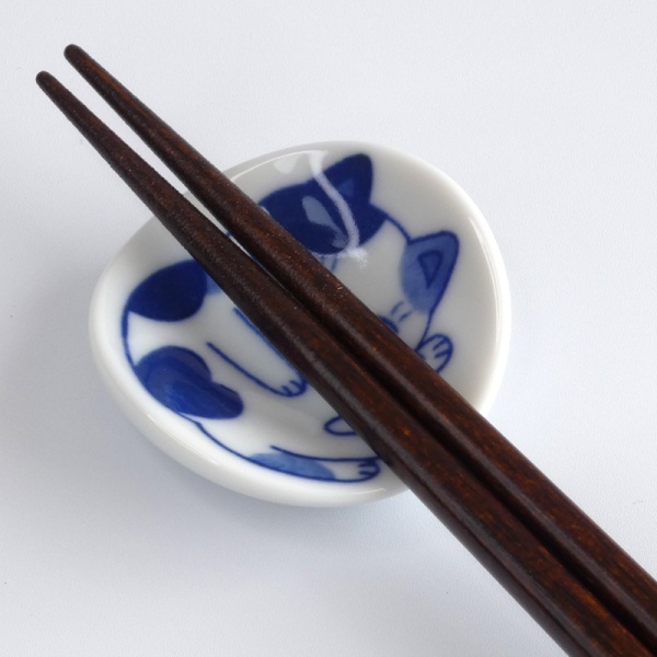 Close up of calico cat chopstick rest with chopsticks