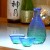 'Ocean' blue green glass sake jug and cups on bar