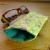 Handmade quilted glasses case in yellow vine floral print - shown with glasses