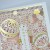 Close up of intricate laser-cut design with gold highlights and pastel coloured temari background showing through