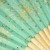 Close up of pale green and gold fireworks design on Japanese fan